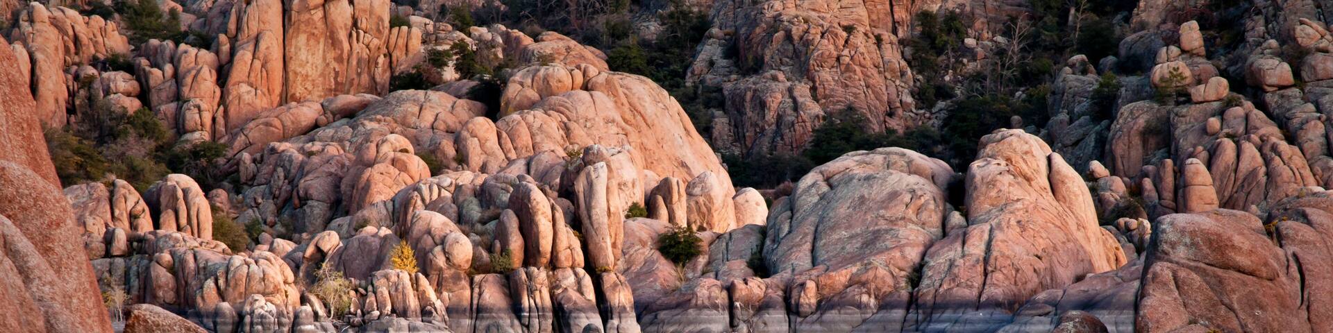 The granite rock formations of the Granite Dells area of Watson Lake glow in the twilight of a fading southwestern sunset. Prescott, Arizona.