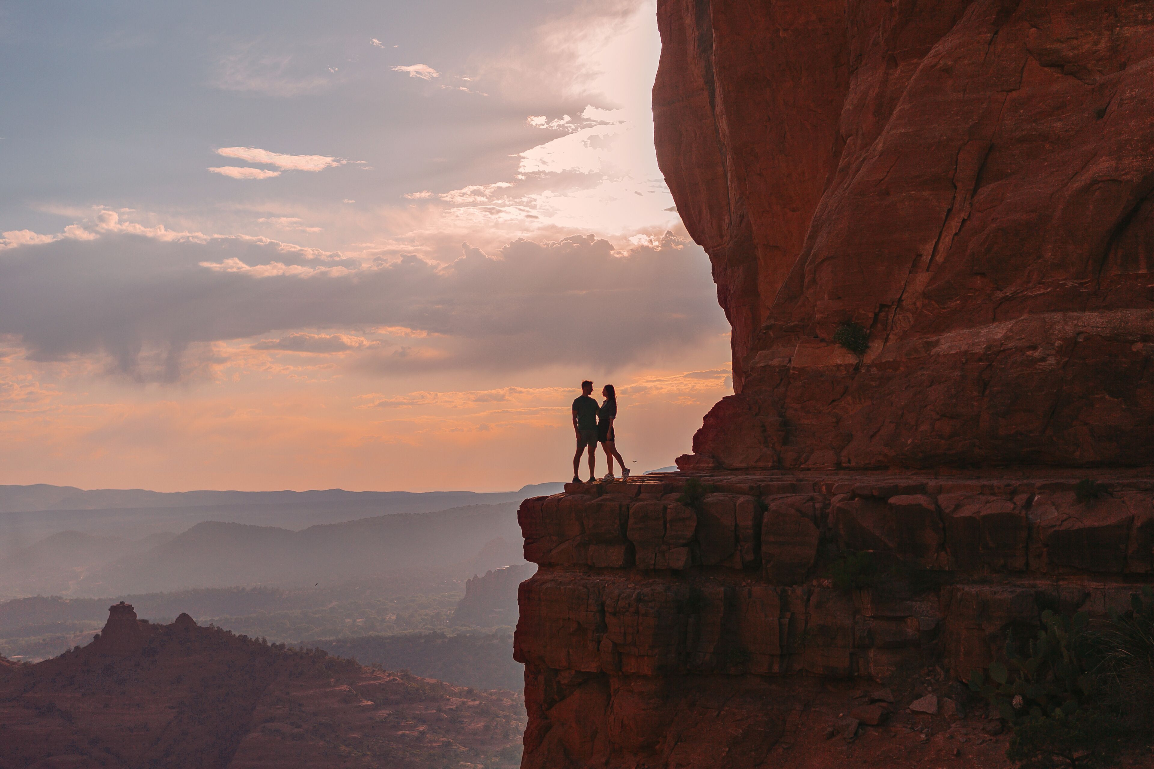 Silhouette of woman and man on the trail at Cathedral Rock at sunset in Sedona. The colourful sunset over Sedona's Cathedral Rock landmark.