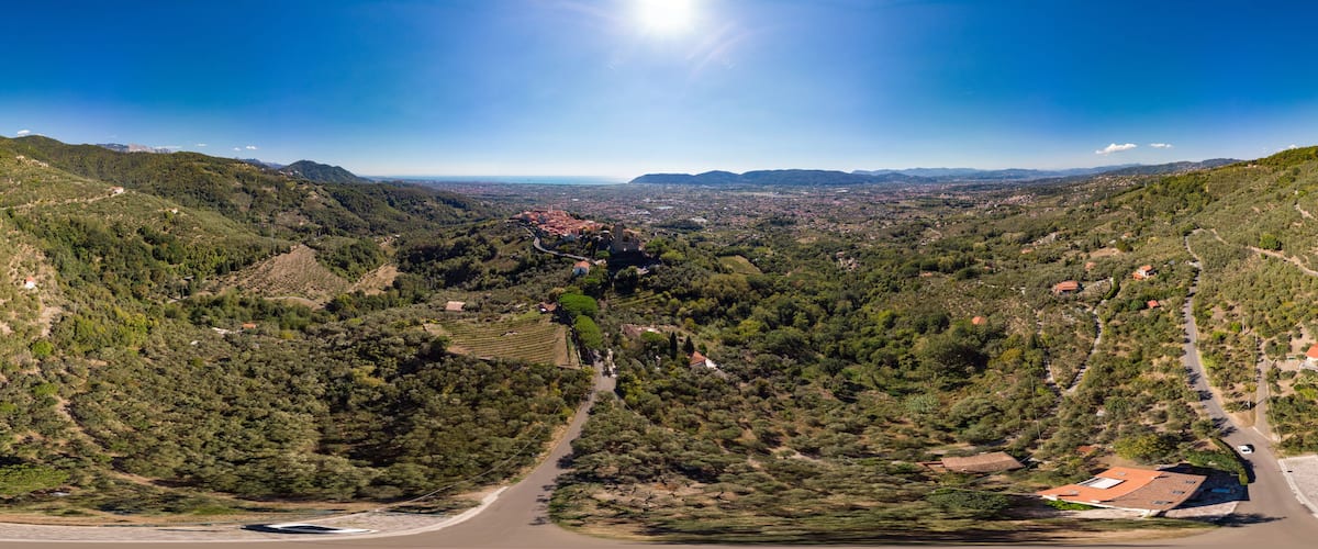 A valley with a road, a small town, and surrounding hills.