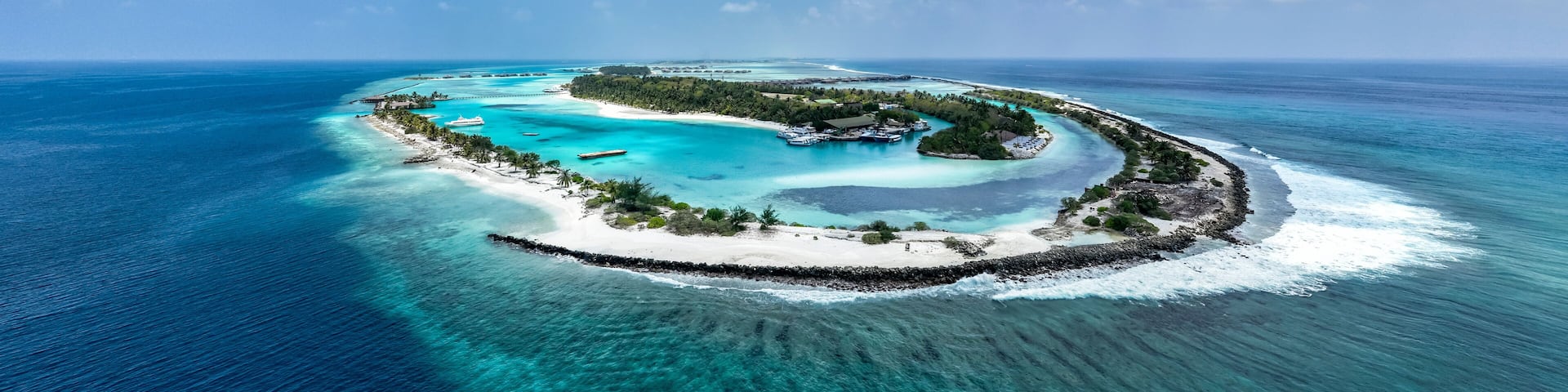 A tropical island surrounded by turquoise waters and clear skies.