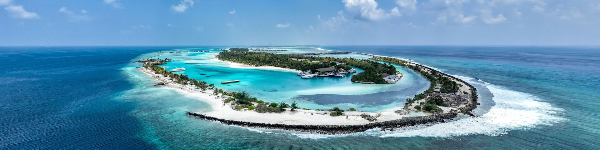 Uma ilha tropical rodeada por águas azul-turquesa e céu claro.