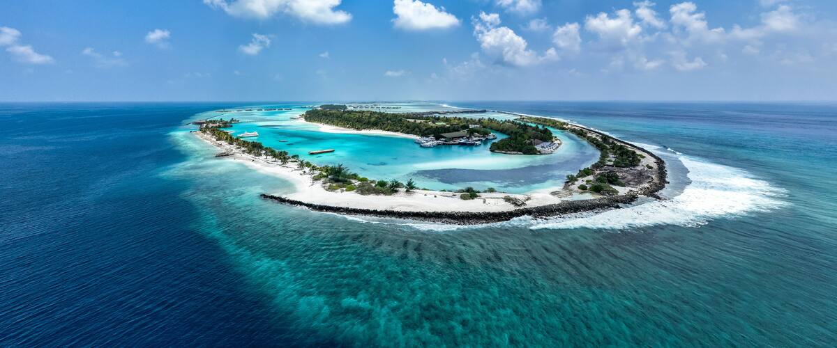A tropical island surrounded by turquoise waters and clear skies.