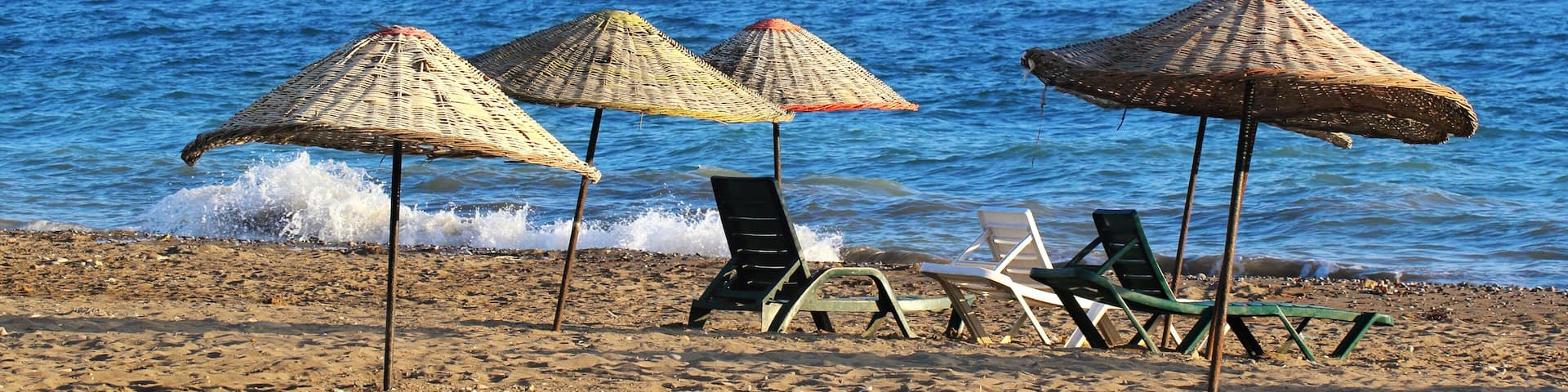 Many straw beach umbrellas at the seashore in Gumuldur, Turkey