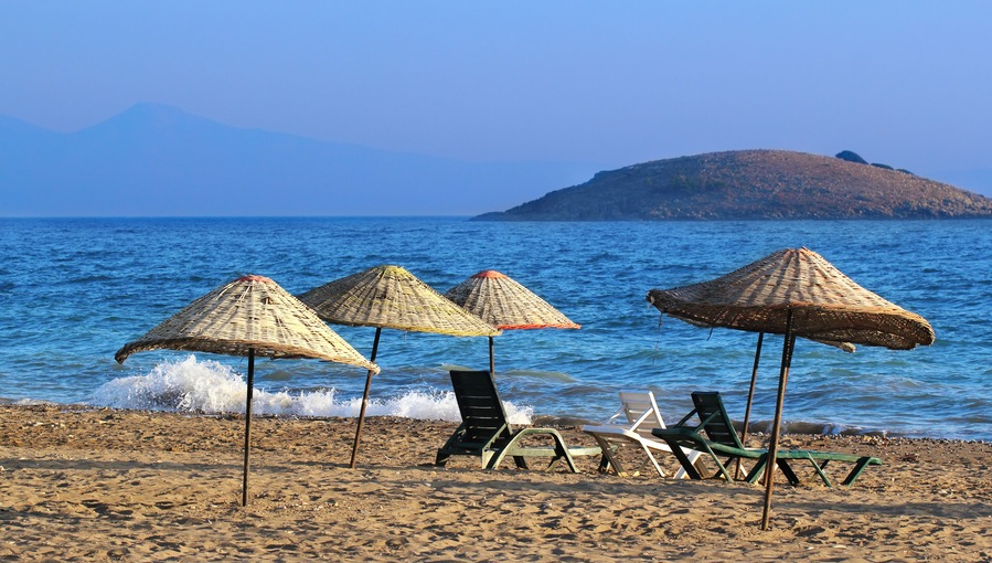 Many straw beach umbrellas at the seashore in Gumuldur, Turkey