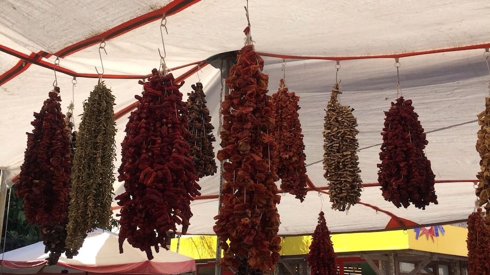 Un puesto de mercado con hierbas y especias secas colgando.