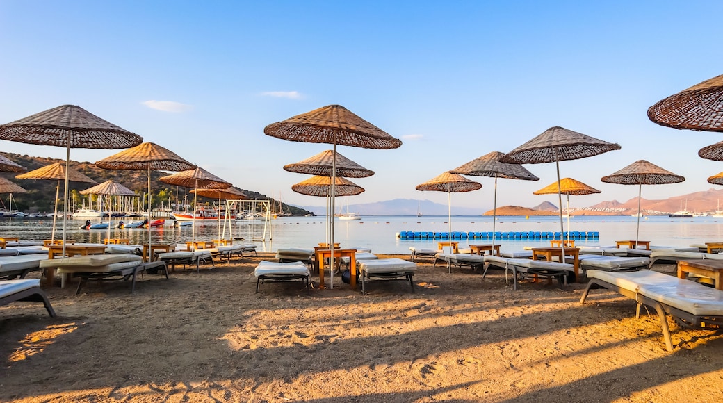 Beautiful beach on the shores of the calm blue bay of the Aegean Sea in the early morning. Beach vacation and holiday destination concept. Bitez, Bodrum, Turkey