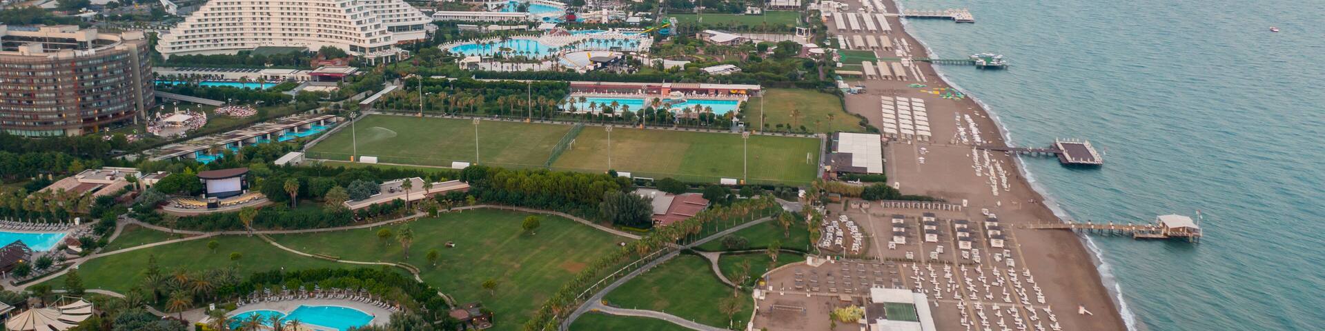 Sandy beaches of the Mediterranean. Kundu - Belek holiday complex with five star hotels. Beach, sea, water sports, parasailing, entertainment and shopping center Aerial view with drone. Antalya-TURKEY