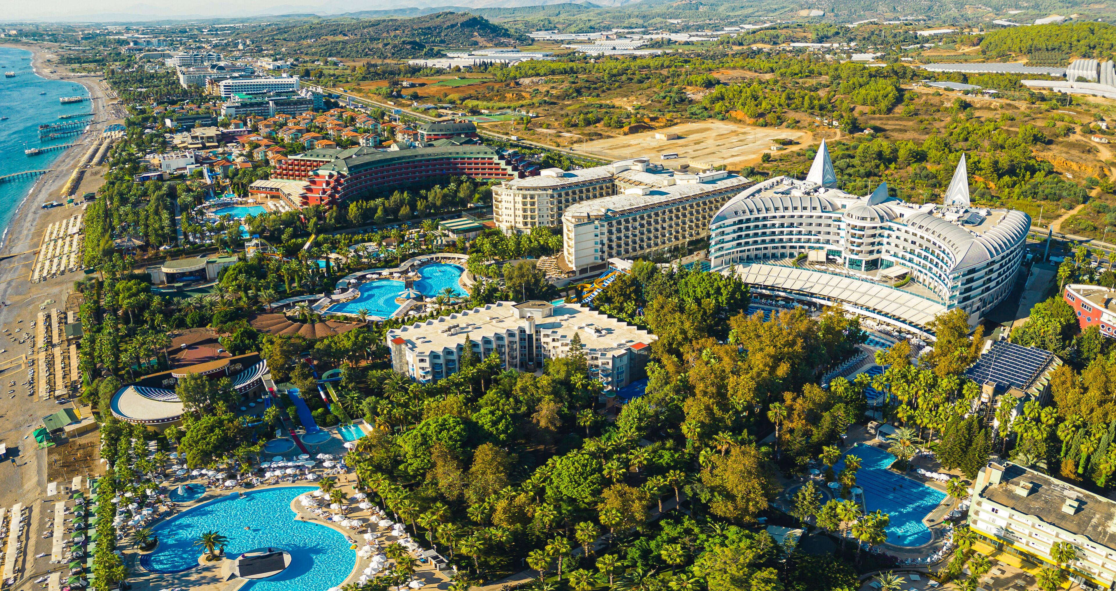scenic drone shot of luxury hotels near the sea, pools and palm trees, Okurcalar, Turkey. High quality photo