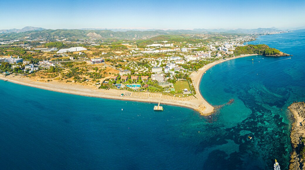 Okurcalar, Alanya, Turkey. Drone view of the wide blue transparent Mediterranean sea, reef under the water, a sandy coastline around the resort city. High quality photo