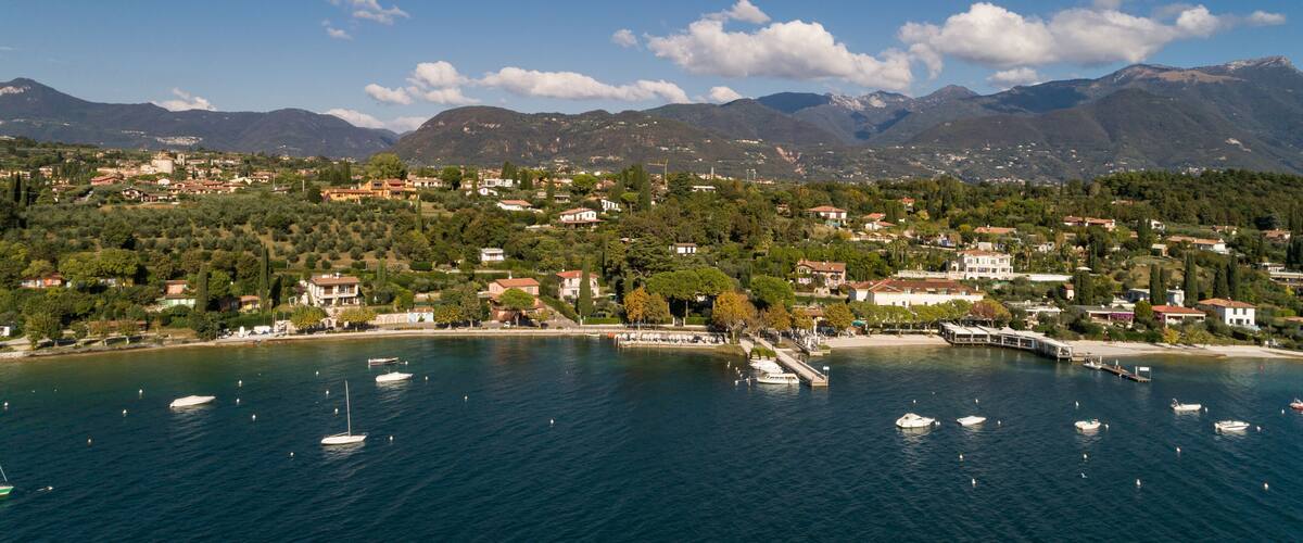 A coastal town with boats, mountains, and clear skies.