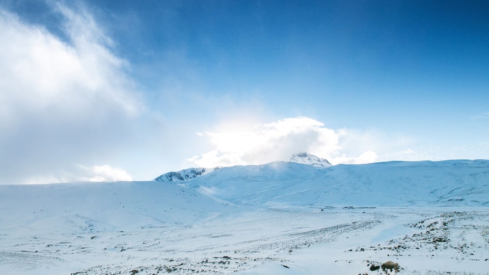 A snow-covered mountain range under a clear blue sky.