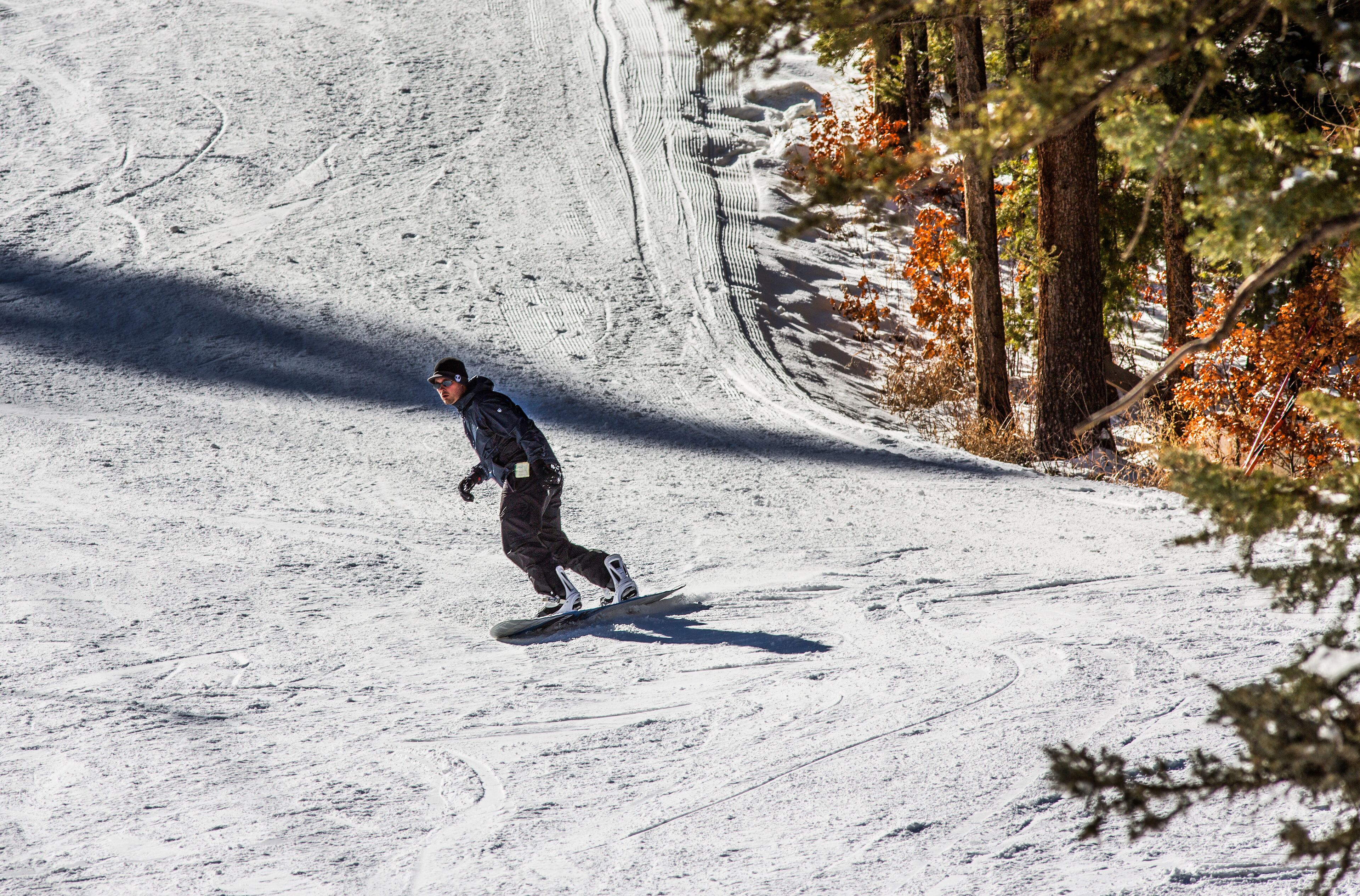 snowboarder coming in to the bottom of the ski resort 