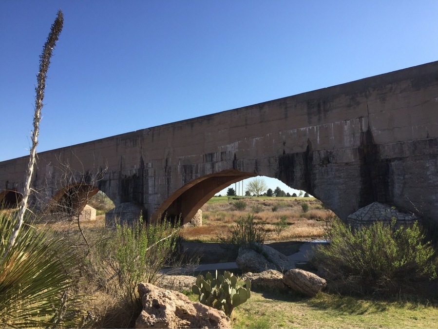 This irrigation flume continuously leaks water onto the roadway below as it ages gracefully since its 1929 completion. It replaced the original wooden structure built in the 1880s that eventually collapsed. A stone cottage was built adjacent to this spot for the water manager to live in while maintaining water levels for the farmers and citizens of Carlsbad.