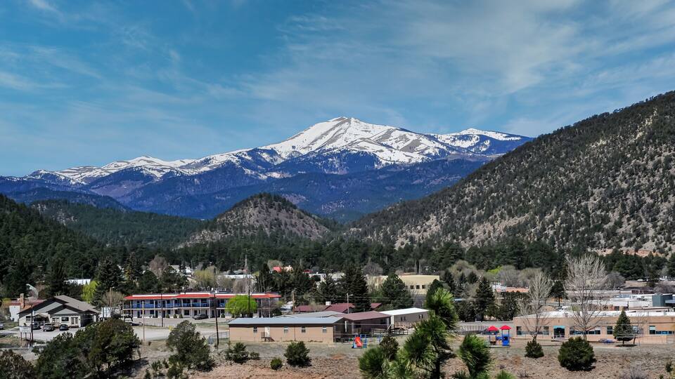 A town with buildings and a mountain range in the background.