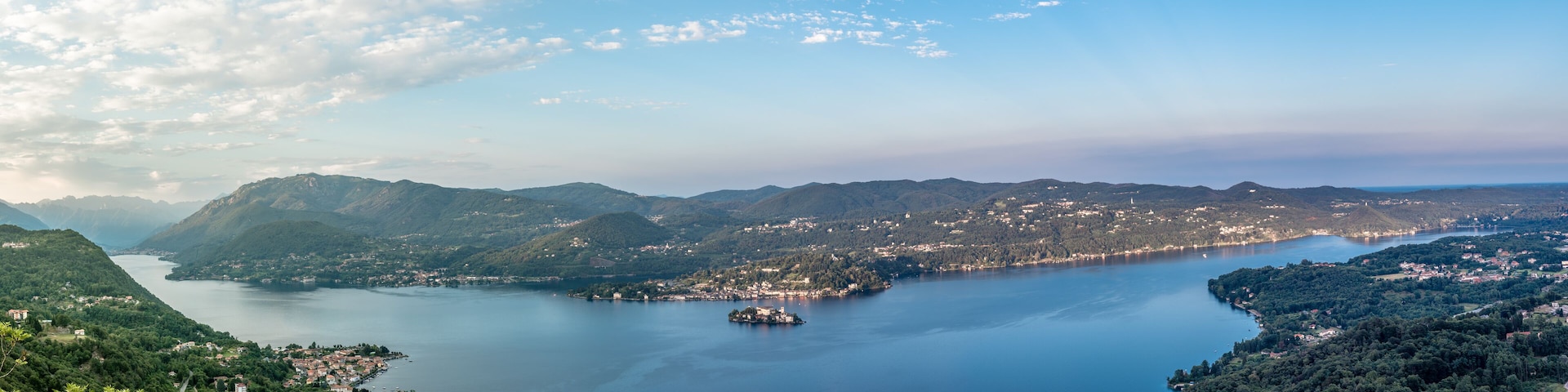 A lake surrounded by mountains and a small island with buildings.