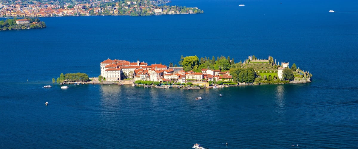 A lake with a historic island featuring red-roofed buildings and a castle.