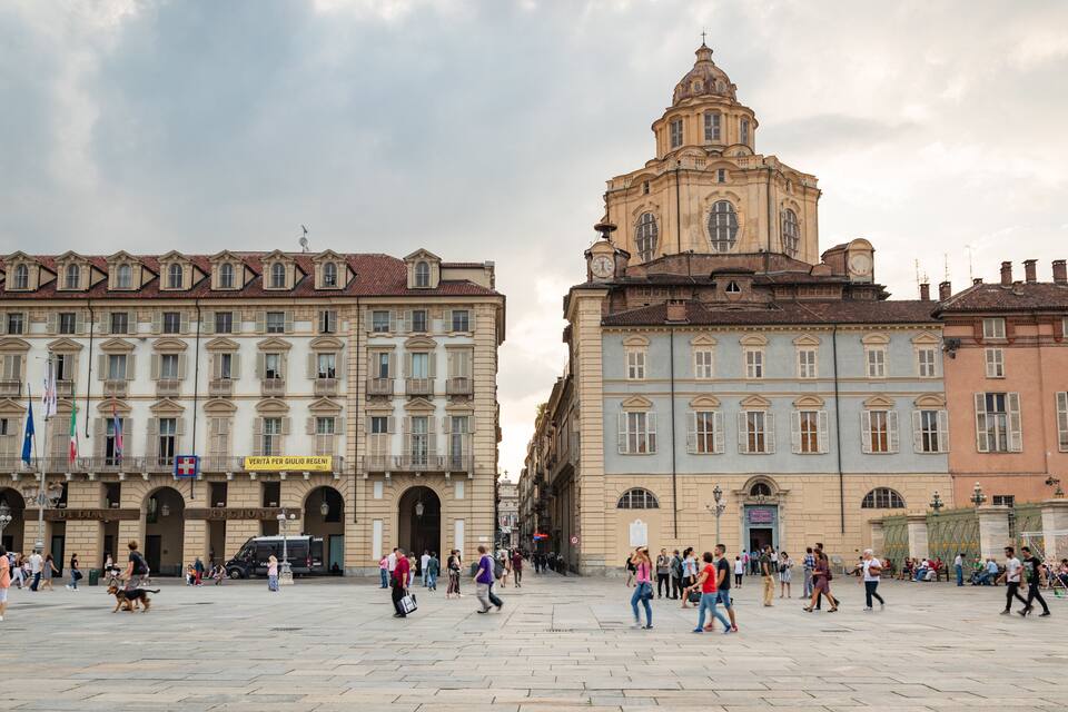 Uma praça histórica com uma igreja imponente e arquitetura clássica.