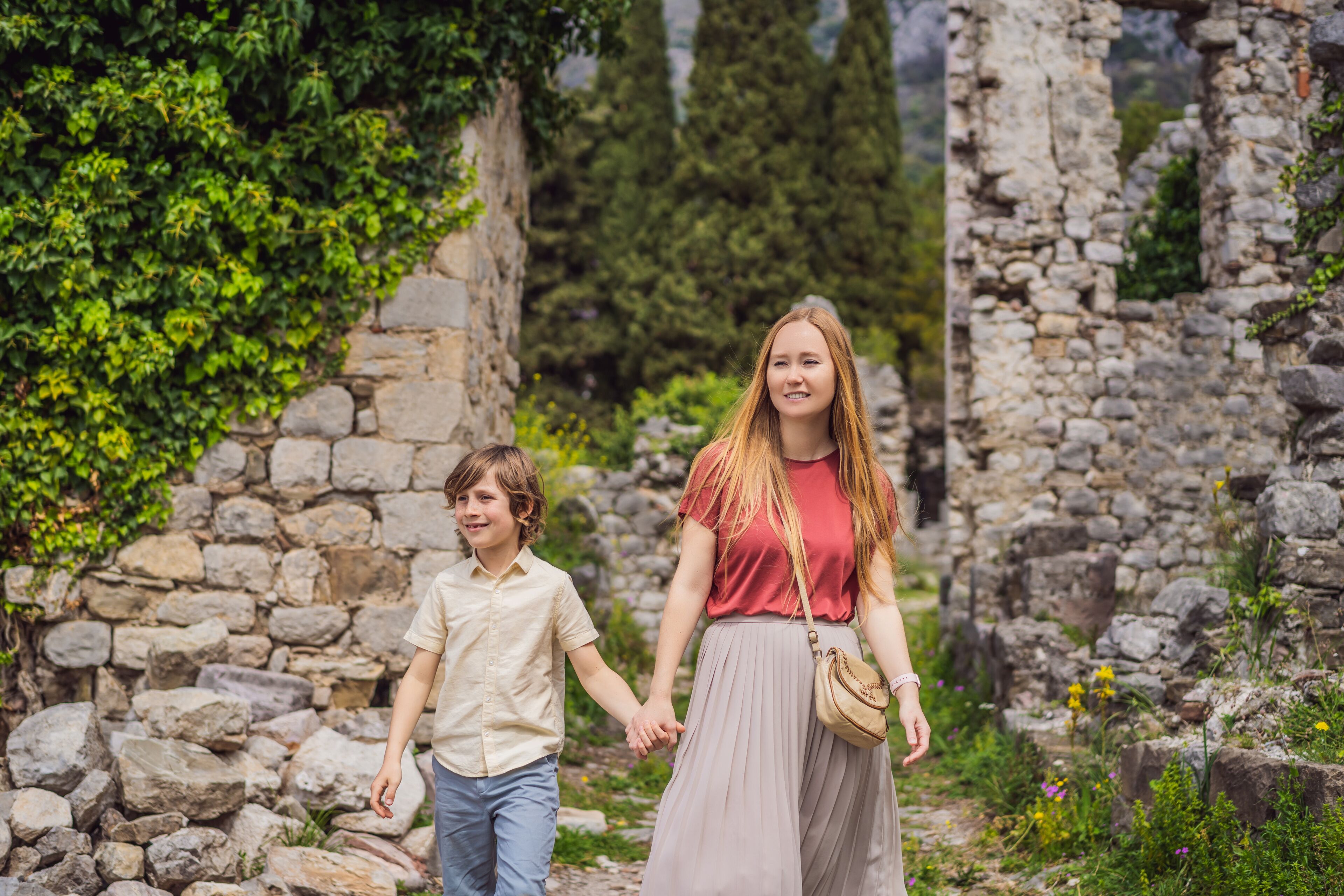 Mom and son tourists walks through the old town of Bar in Montenegro. Happy tourist walks in the mountains. Suburbs of the city of Bar, Montenegro, Balkans. Beautiful nature and landscape