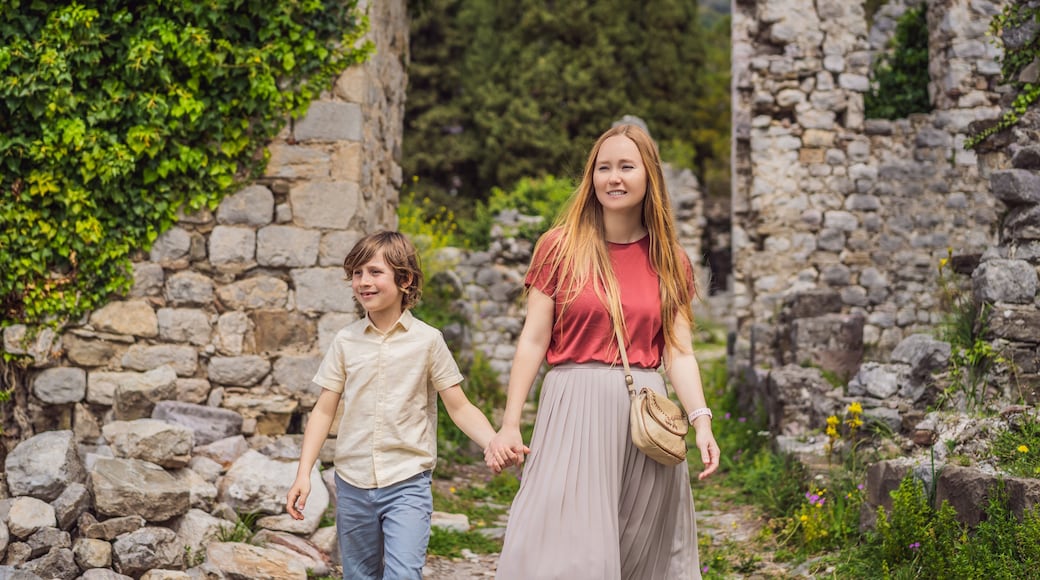 Mom and son tourists walks through the old town of Bar in Montenegro. Happy tourist walks in the mountains. Suburbs of the city of Bar, Montenegro, Balkans. Beautiful nature and landscape
