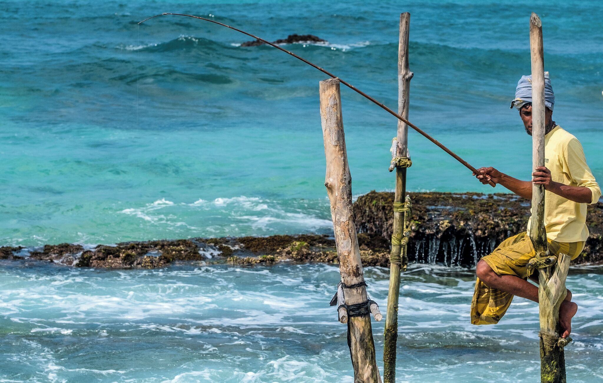 Ritipanna is the Sinhalese term for stilt fishing, which is a traditional method for fishing practiced by most fishermen along the southern coast of Sri Lanka. This art is popularly seen in areas such as Ahangama, Koggala, Welipenna, Kathaluwa and Thalarambe. A narrow pole is tied to a stick that is anchored on the sea bed. Fisher folk climb onto this stick and settle on the pole for a few hours in an effort to catch some fish.

Fishermen found on stilts are those who do not have access to sophisticated equipment for fishing. These men can make a living simply with the help of two wooden poles to make a stilt. One pole is nailed onto the sea bed and the other is placed like a cross bar and acts as a plank for the fishermen to sit on. Each stilt can accommodate only one fisherman. For catching fish, they create a rod made of Kithul, and a small plastic bag is tied around their waist to hold the fish that they catch. With one hand they hold onto the stilt and with the other they hold the rod that catches fish. The tradition of stilt fishing will always be practiced by those who cannot afford to invest in modern fishing equipment.

#likealocal