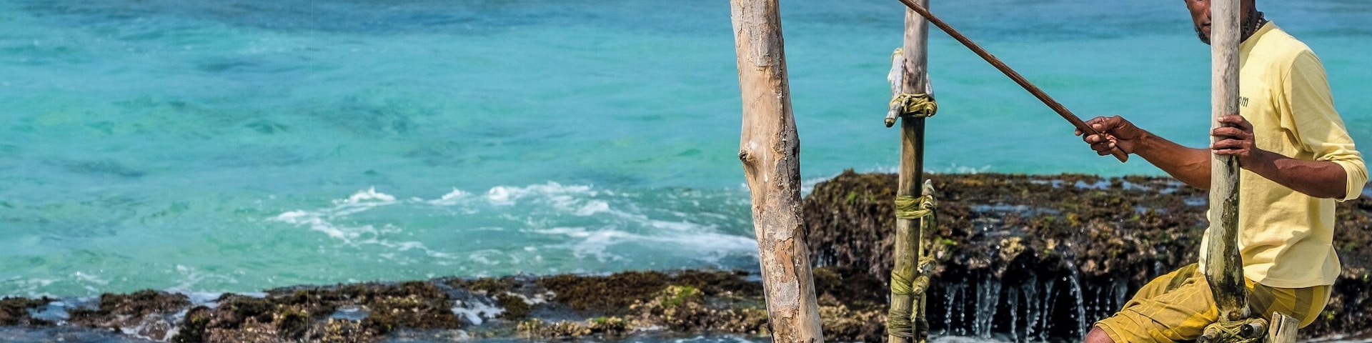 Ritipanna is the Sinhalese term for stilt fishing, which is a traditional method for fishing practiced by most fishermen along the southern coast of Sri Lanka. This art is popularly seen in areas such as Ahangama, Koggala, Welipenna, Kathaluwa and Thalarambe. A narrow pole is tied to a stick that is anchored on the sea bed. Fisher folk climb onto this stick and settle on the pole for a few hours in an effort to catch some fish.
Fishermen found on stilts are those who do not have access to sophisticated equipment for fishing. These men can make a living simply with the help of two wooden poles to make a stilt. One pole is nailed onto the sea bed and the other is placed like a cross bar and acts as a plank for the fishermen to sit on. Each stilt can accommodate only one fisherman. For catching fish, they create a rod made of Kithul, and a small plastic bag is tied around their waist to hold the fish that they catch. With one hand they hold onto the stilt and with the other they hold the rod that catches fish. The tradition of stilt fishing will always be practiced by those who cannot afford to invest in modern fishing equipment.
#likealocal
