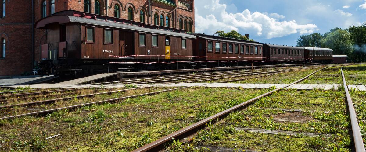 A historic train station with a green roof and brick architecture.
