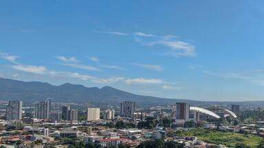 A cityscape with a prominent mountain in the background.