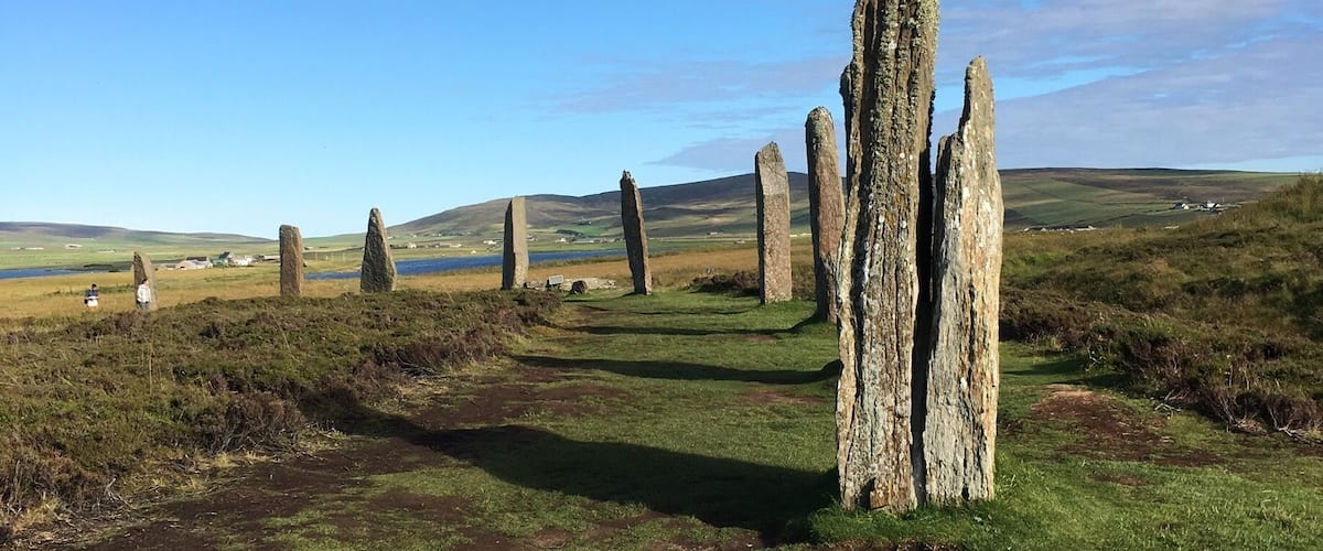 Un cerchio di pietre con menhir in un prato erboso.