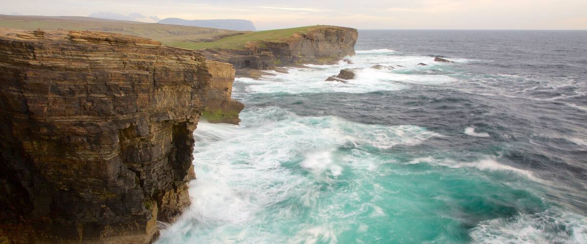 Una costa escarpada con acantilados pronunciados y olas oceánicas agitadas.