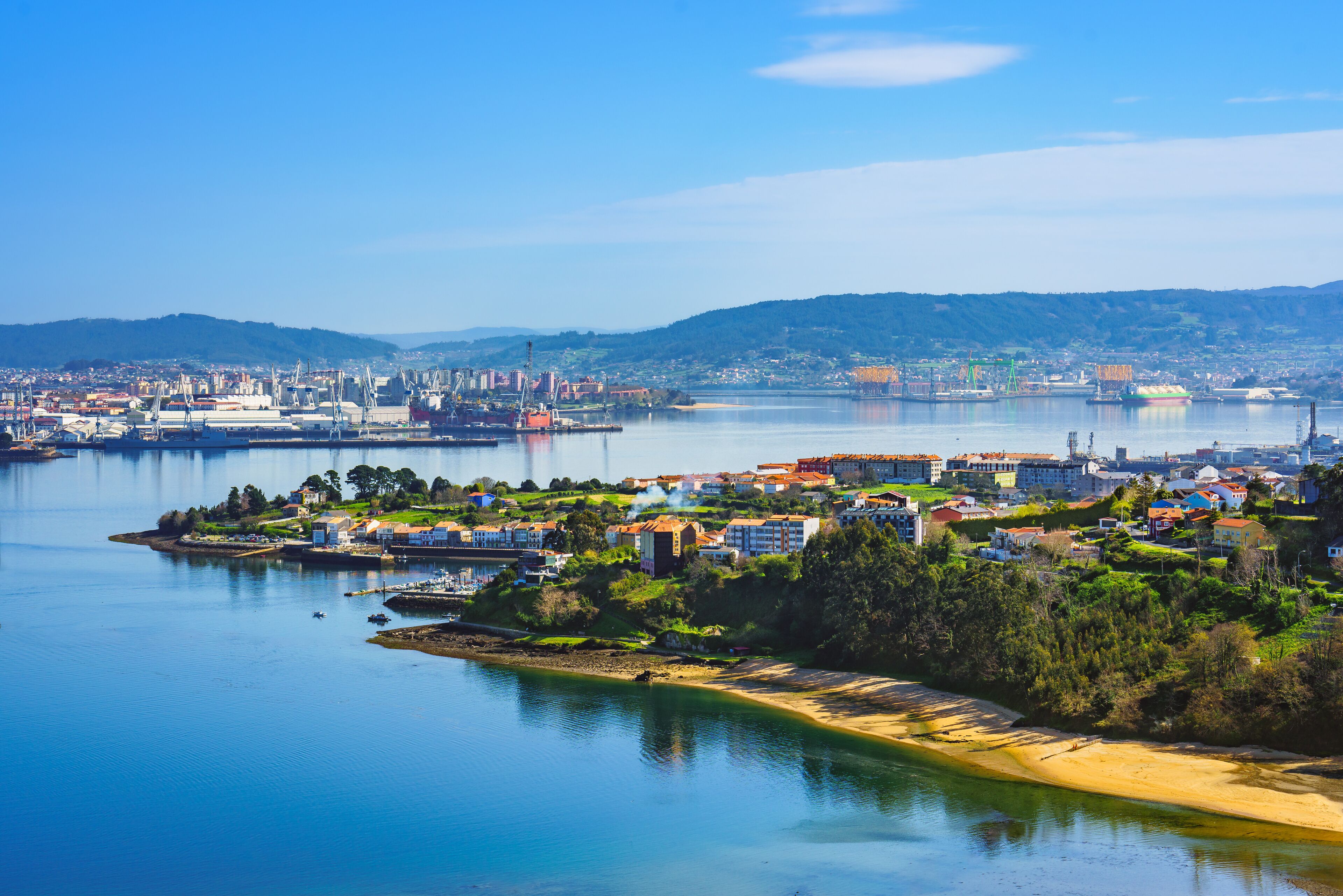 A coastal city with a bay, residential areas, and industrial buildings.
