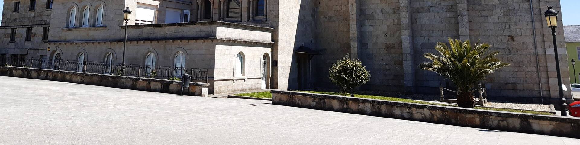 A historic stone building with a bell tower and arched windows.