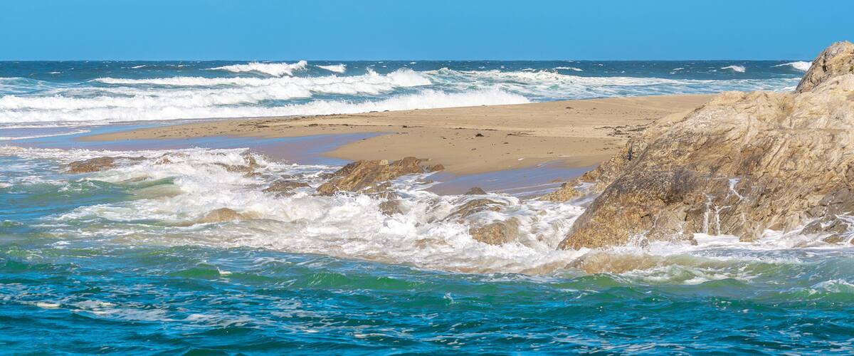 A rocky coastline with waves crashing onto the shore.