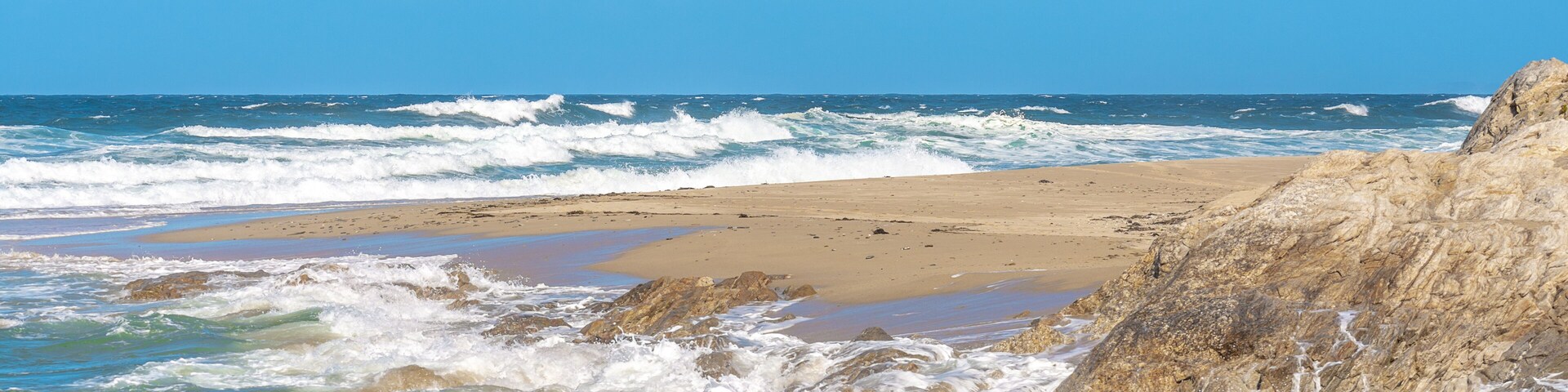 A rocky coastline with waves crashing onto the shore.