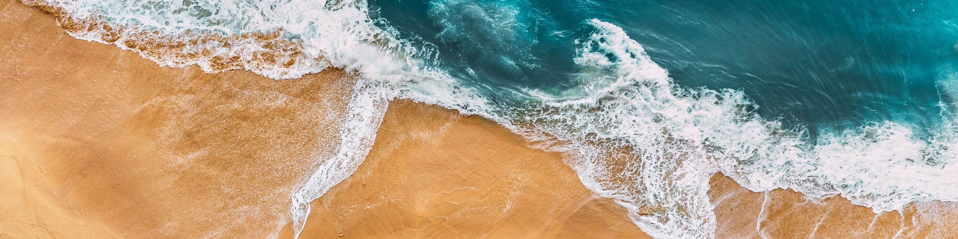 A sandy beach with waves crashing onto the shore.