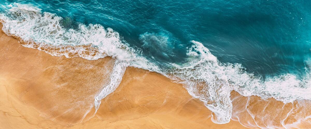 A sandy beach with waves crashing onto the shore.