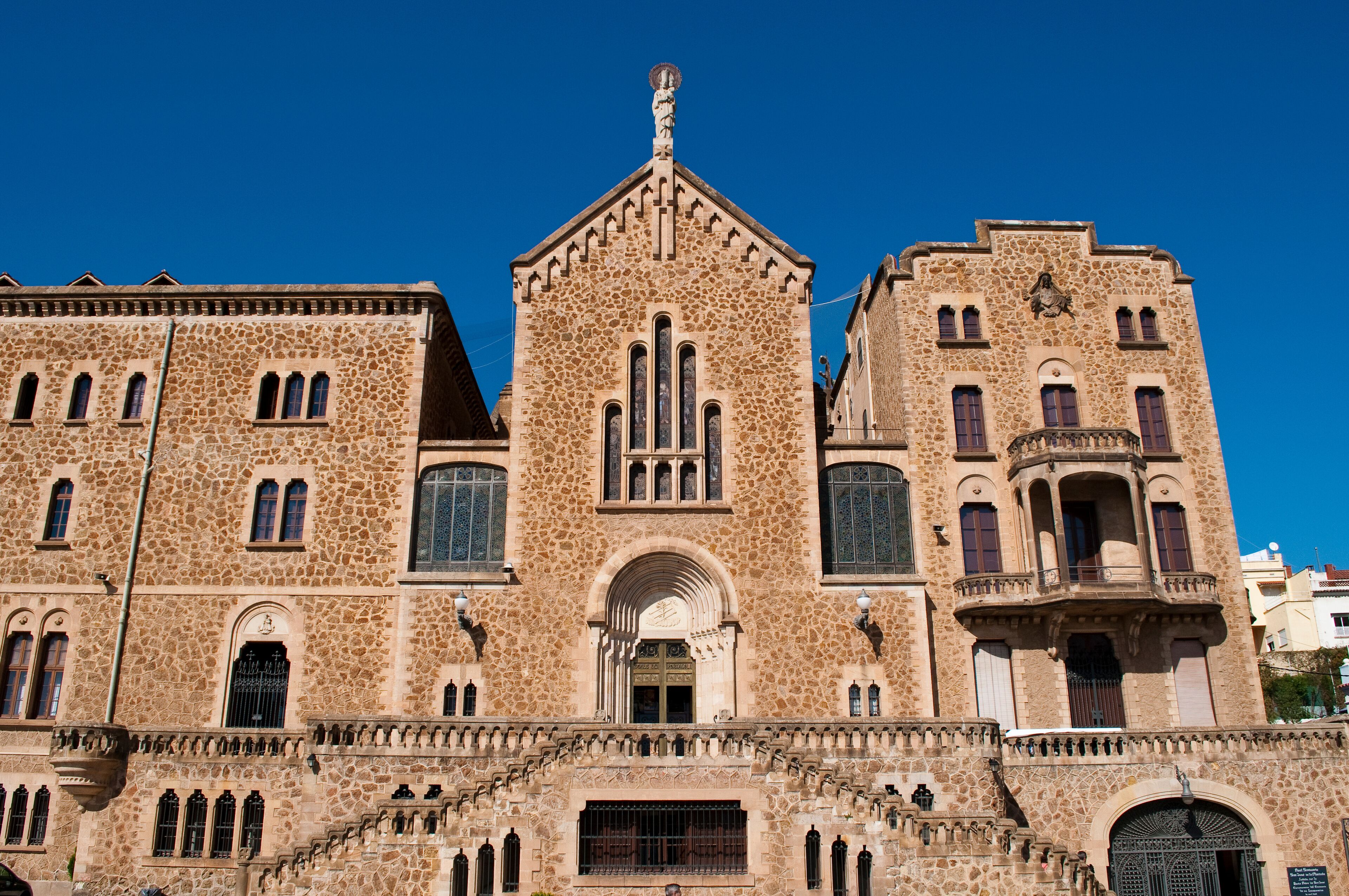 A historic building with a stone facade, arched windows, and a central tower.