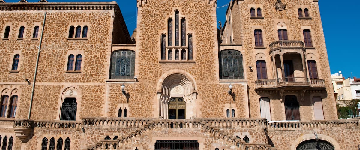A historic building with a stone facade, arched windows, and a central tower.