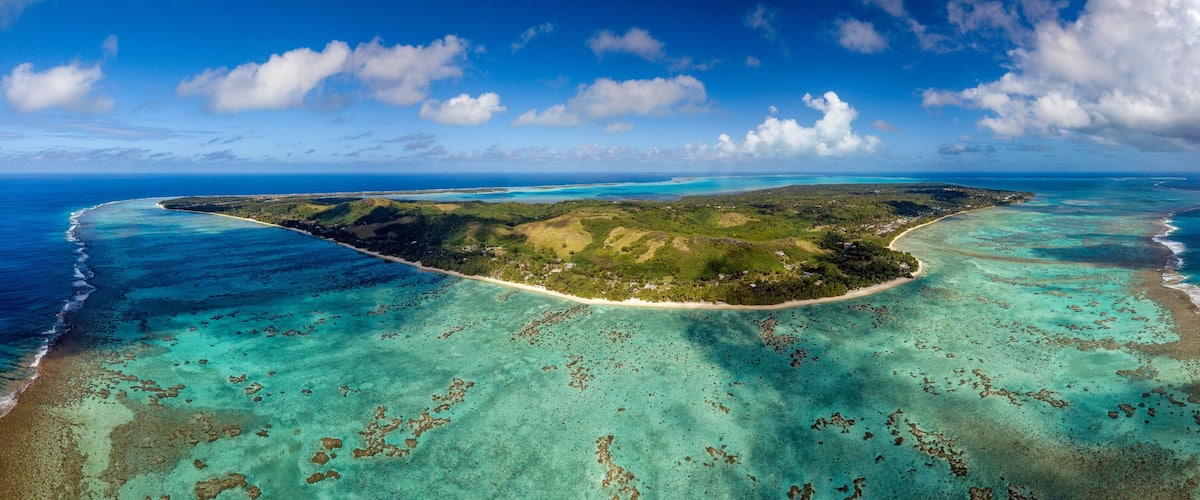 Une vue aérienne d’une île tropicale, avec ses eaux turquoise limpides, ses plages de sable et sa végétation luxuriante.
