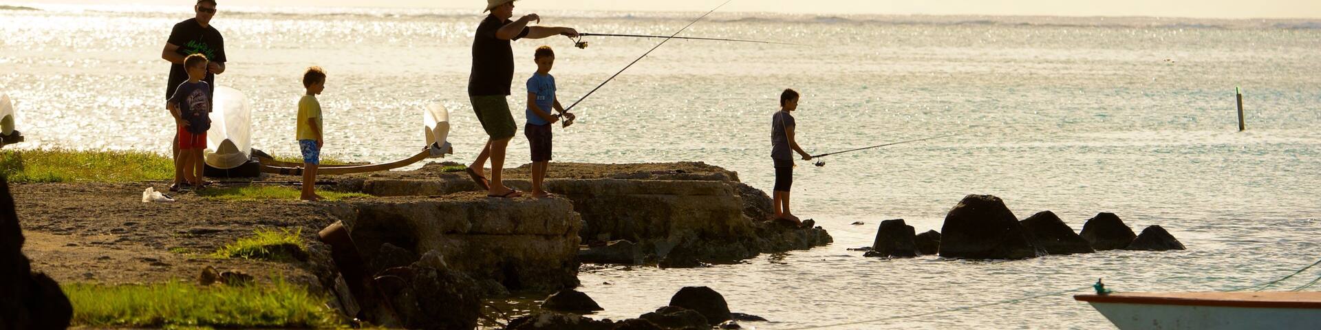Arutanga qui includes pĂȘche et vues littorales aussi bien que petit groupe de personnes