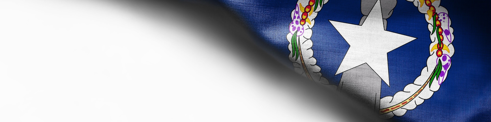 Una bandera con una estrella blanca y un emblema circular con cuentas de colores.