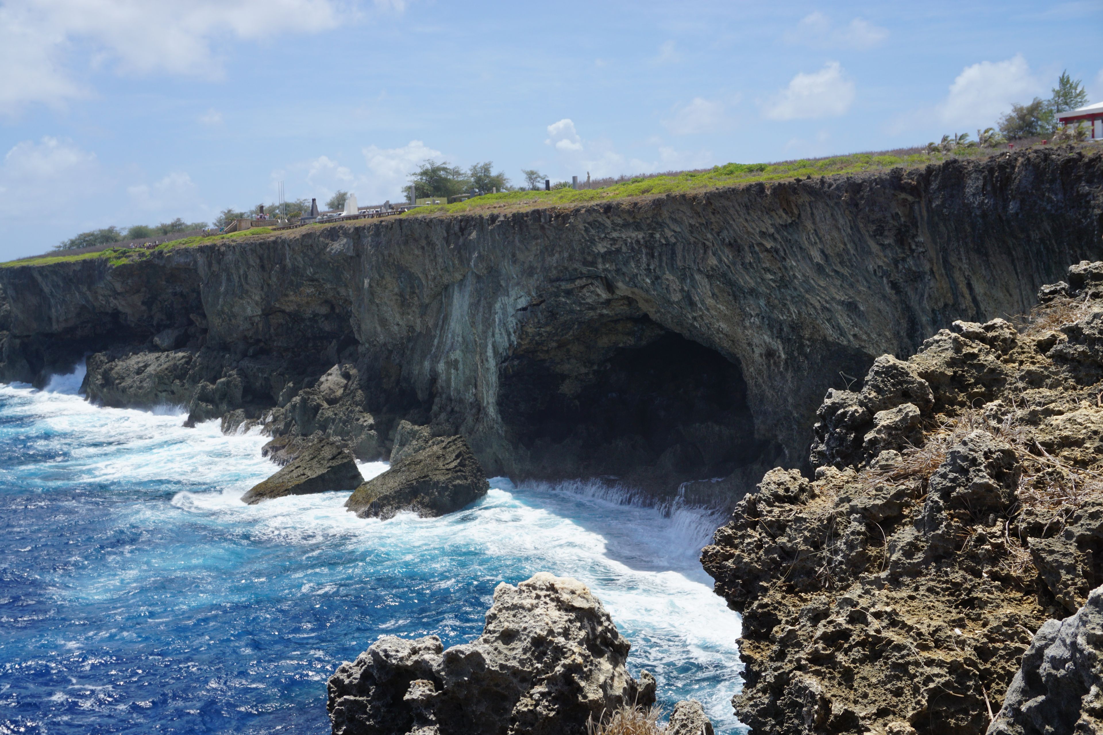 Un paysage côtier caractérisé par une formation rocheuse imposante, notamment une arche naturelle.