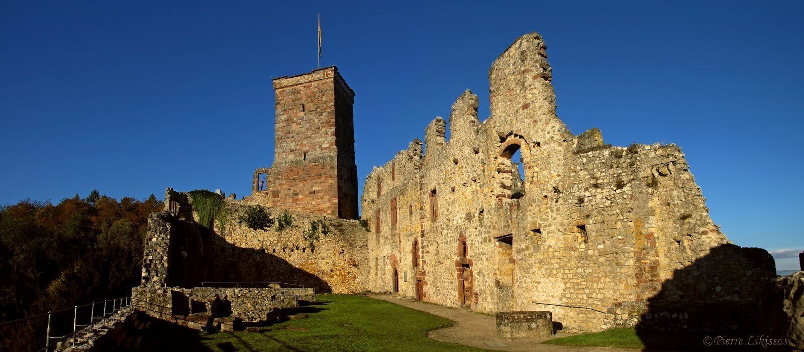 A historic stone castle with a tall tower and ruins.