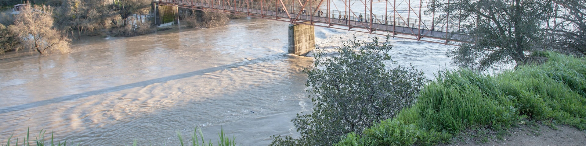 View of the red bridge, Fair Oaks, from the bluffs, with American River in flood