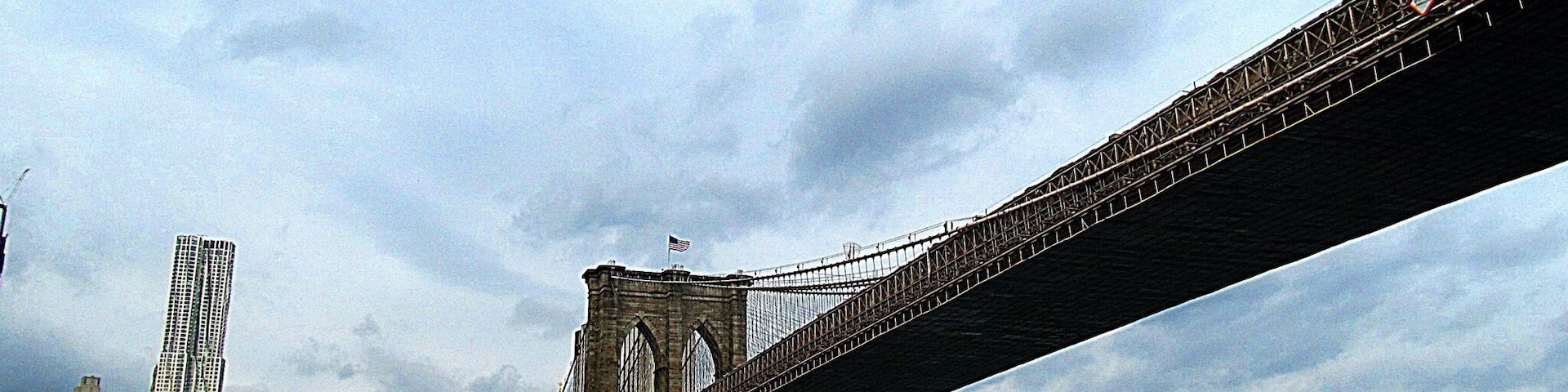 A bridge spanning a river with a city skyline in the background.