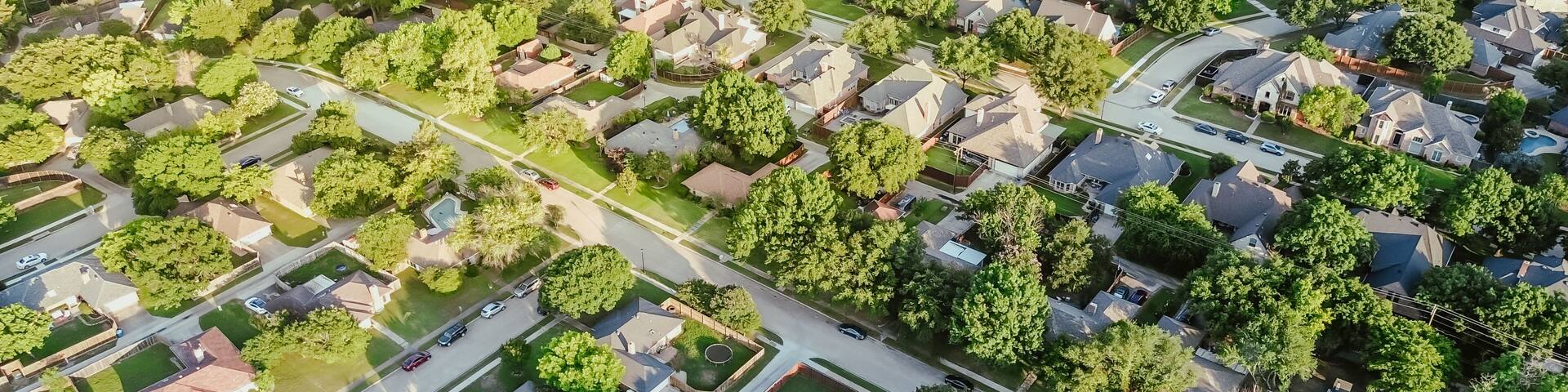 Panorama aerial view residential street in lush greenery neighborhood in Coppell Texas Dallas Fort Worth metroplex, row of detached single-family houses swimming pool, large backyard, grassy lawn