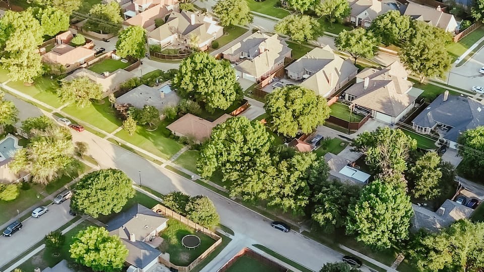 An aerial view of a residential neighborhood with houses, streets, and green spaces.