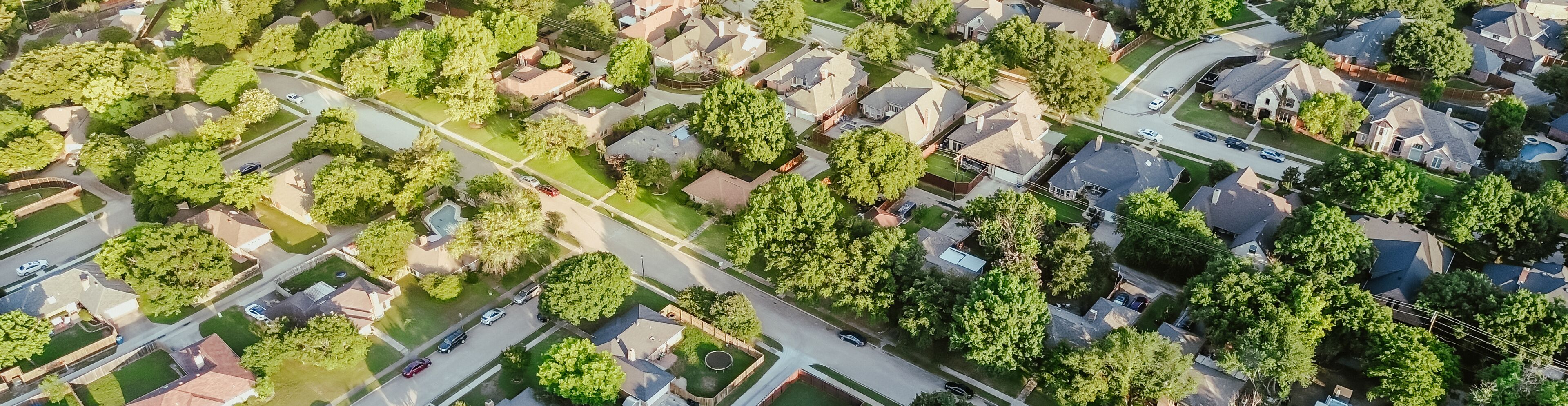 An aerial view of a residential neighborhood with houses, streets, and green spaces.