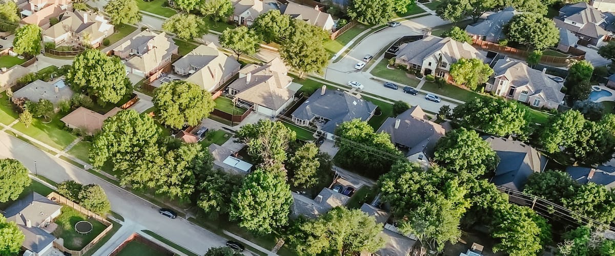 An aerial view of a residential neighborhood with houses, streets, and green spaces.