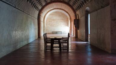Single tables and chairs inside the cloister at Actopan Mexico