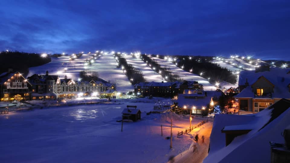 Blue Mountain Ski Resort which includes snow, night scenes and a small town or village